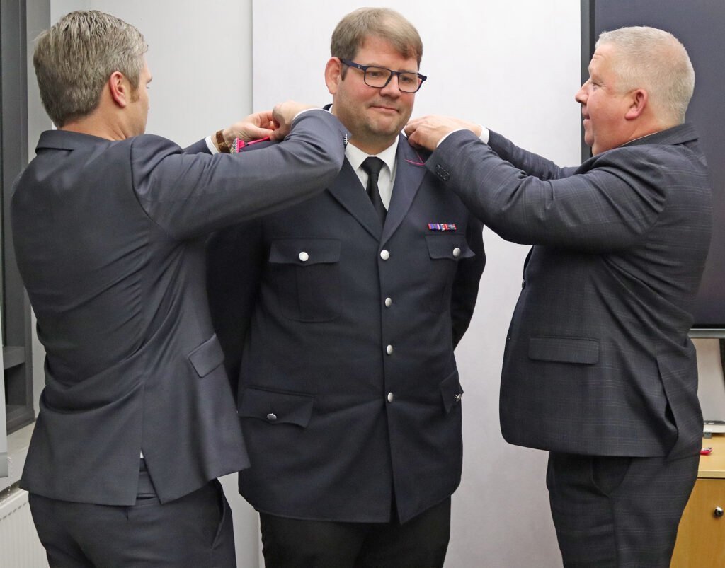 Markus Sältz erhält seine Schulterklappen von Landrat Florian Lorenzen und Kreispräsident Frank Zahel.