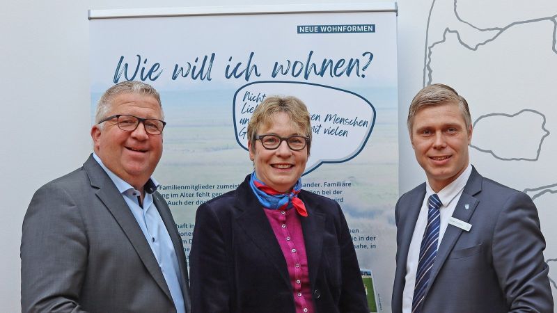 Mehrere Perosnen stehen vor einem Aufstelle auf dem 