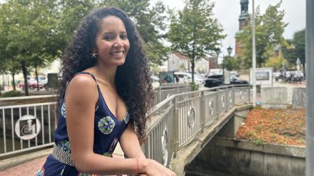 Diana Gerwig Rocha Monteiro auf lehnt an ein Brückengeländer in Tönning