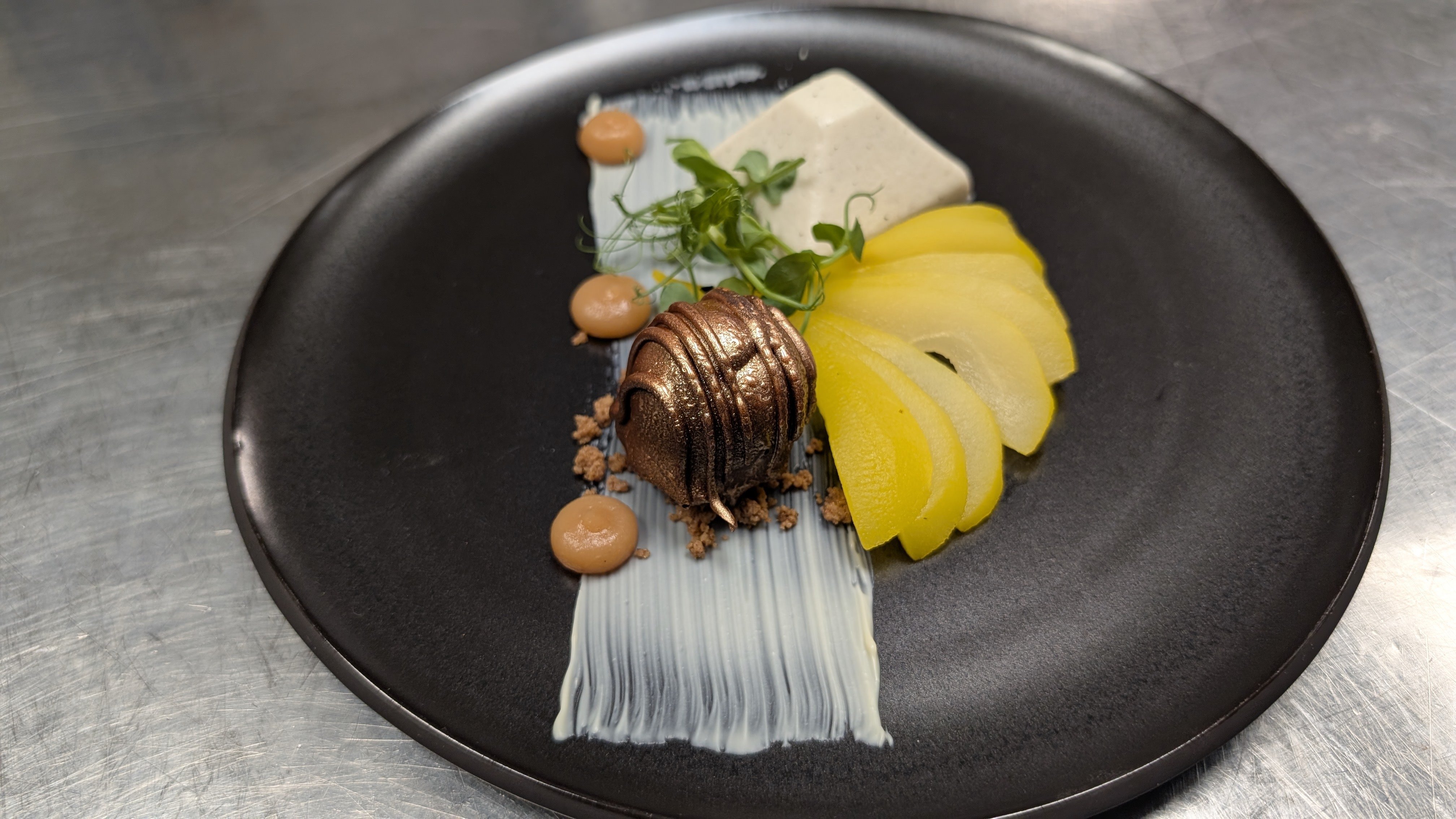Dessert in St. Peter-Ording: Der „Eiderstedter Traum“ besteht aus einer Virunga-Schokoladenkugel mit Eis sowie pochierter Gewürzbirne mit Kardamom.