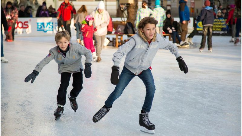 Zwei Kinder auf einer Eisbahn.