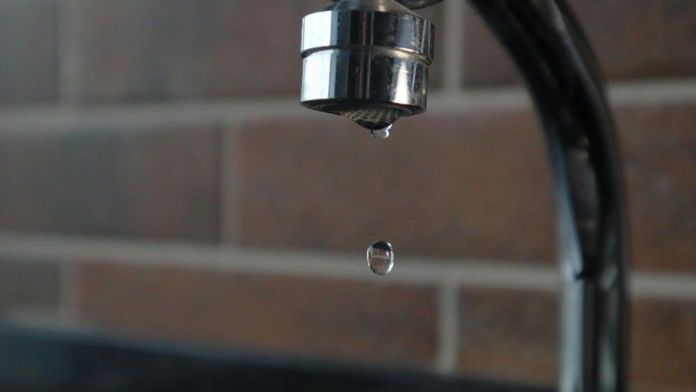 Auf einem Wasserhahn tropft es.