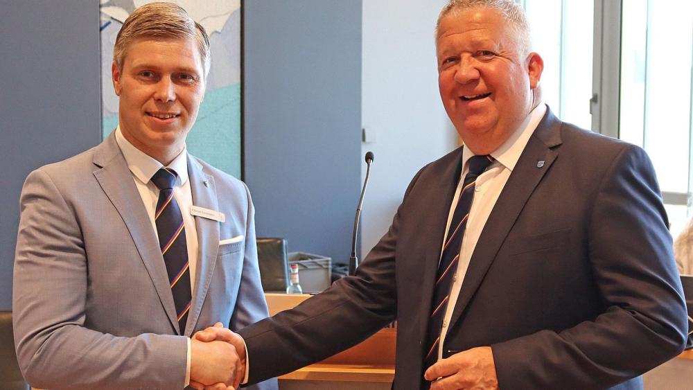 Zwei Männer in Anzügen schütteln einander die Hand