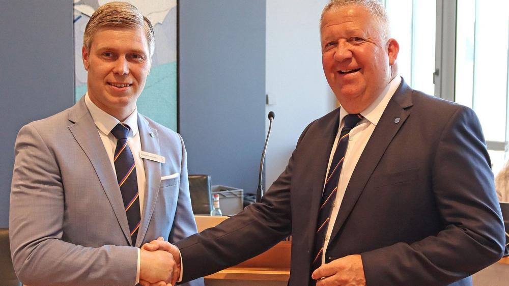Zwei Männer in Anzügen schütteln einander die Hand