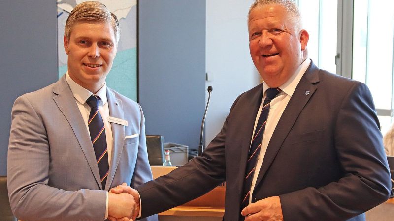 Zwei Männer in Anzügen schütteln einander die Hand