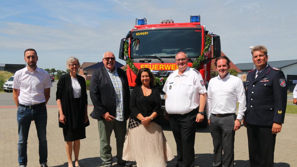 Menschen stehen vor einem LKW der Feuerwehr in Oldenswort.