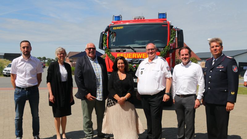 Menschen stehen vor einem LKW der Feuerwehr in Oldenswort.