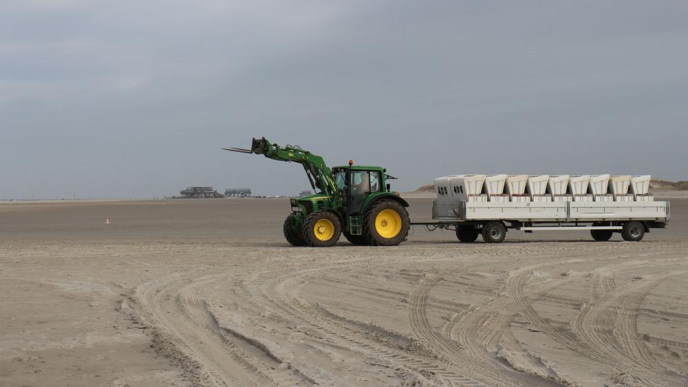 Traktor mit Strandkörben in St. Peter Ording am Sandstrand.