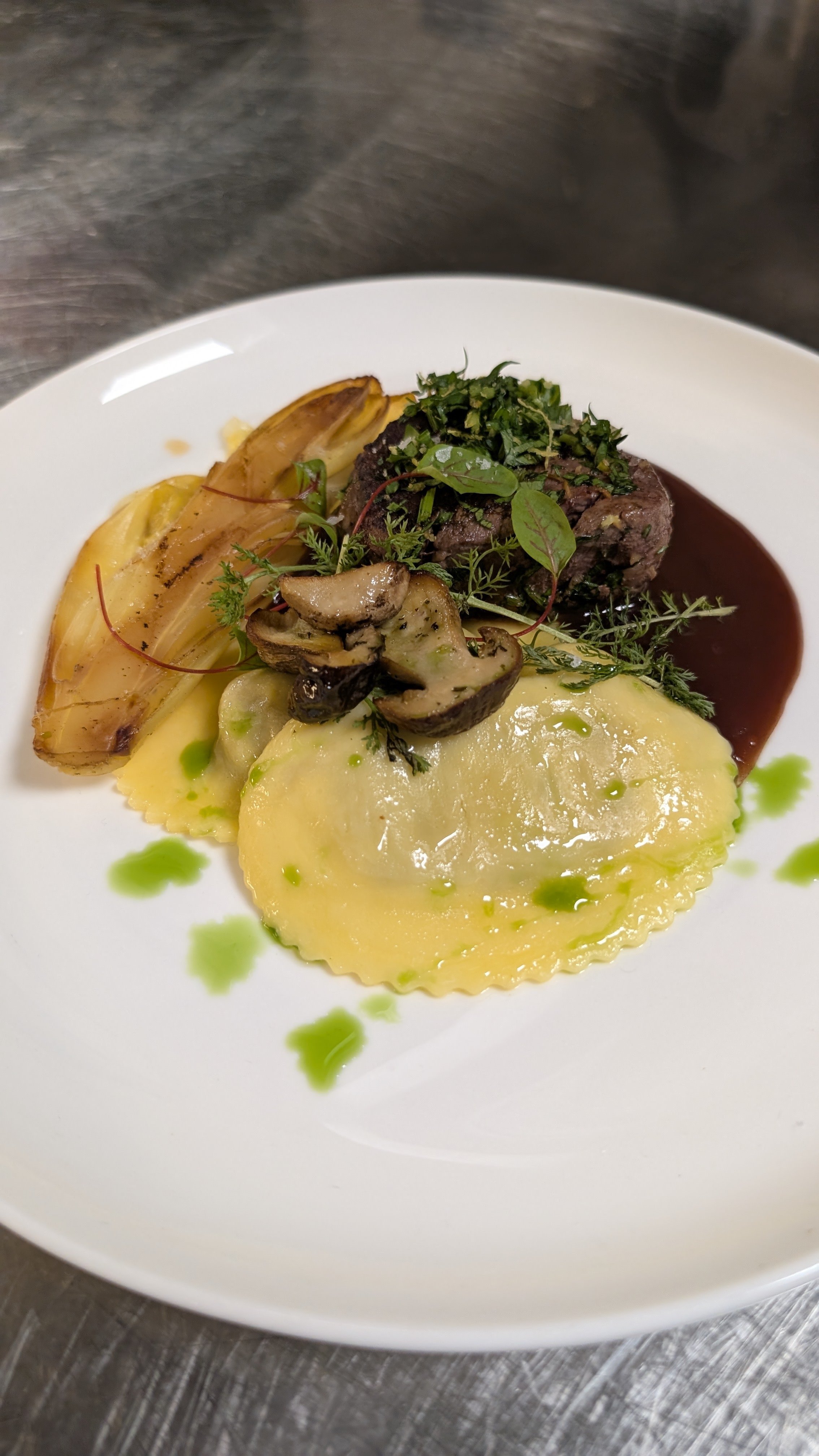 Hauptgang im Restaurant Deichkind in St. Peter-Ording: Rinderfilet mit Gewürz-Gremolata, gegrilltem Chicorée, Steinpilz-Ravioli und Barolo-Jus