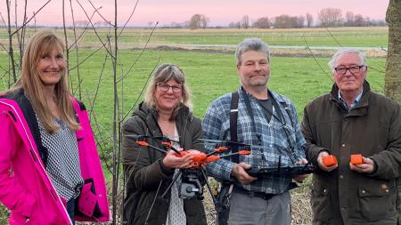 Vier Menschen vor einem Feld.