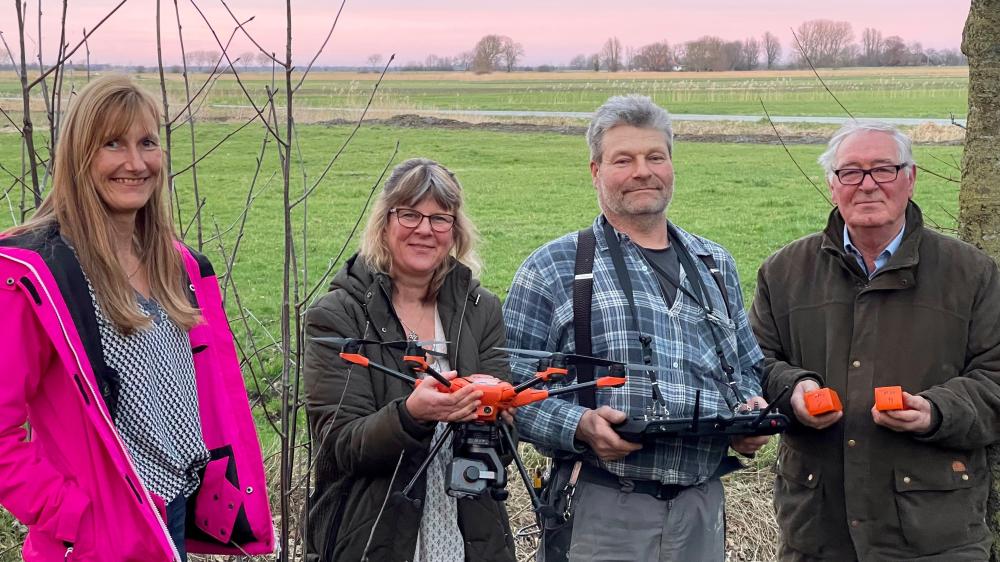 Vier Menschen vor einem Feld.